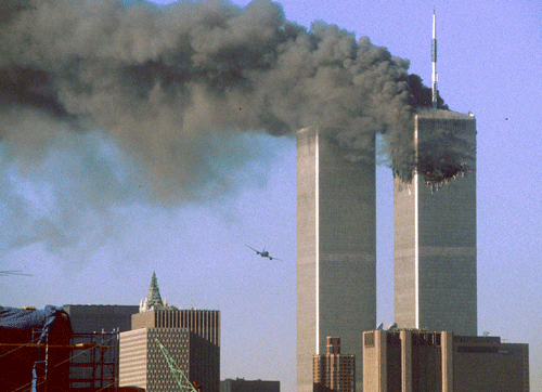 United Airlines Flight 175 flies low toward the South Tower of the World Trade Center, shortly before slamming into the structure. The north tower burns after an earlier attack by a hijacked airliner in New York City, on September 11, 2001. (Reuters/Sean Adair)